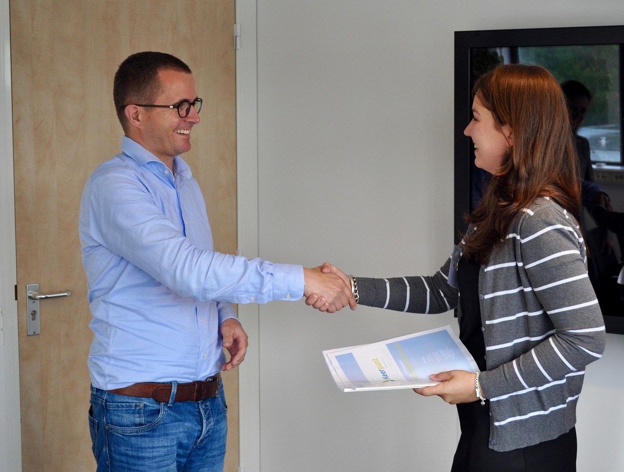 Two people shaking hands in an office