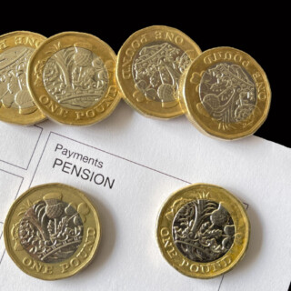 Pound coins on a pension payments document